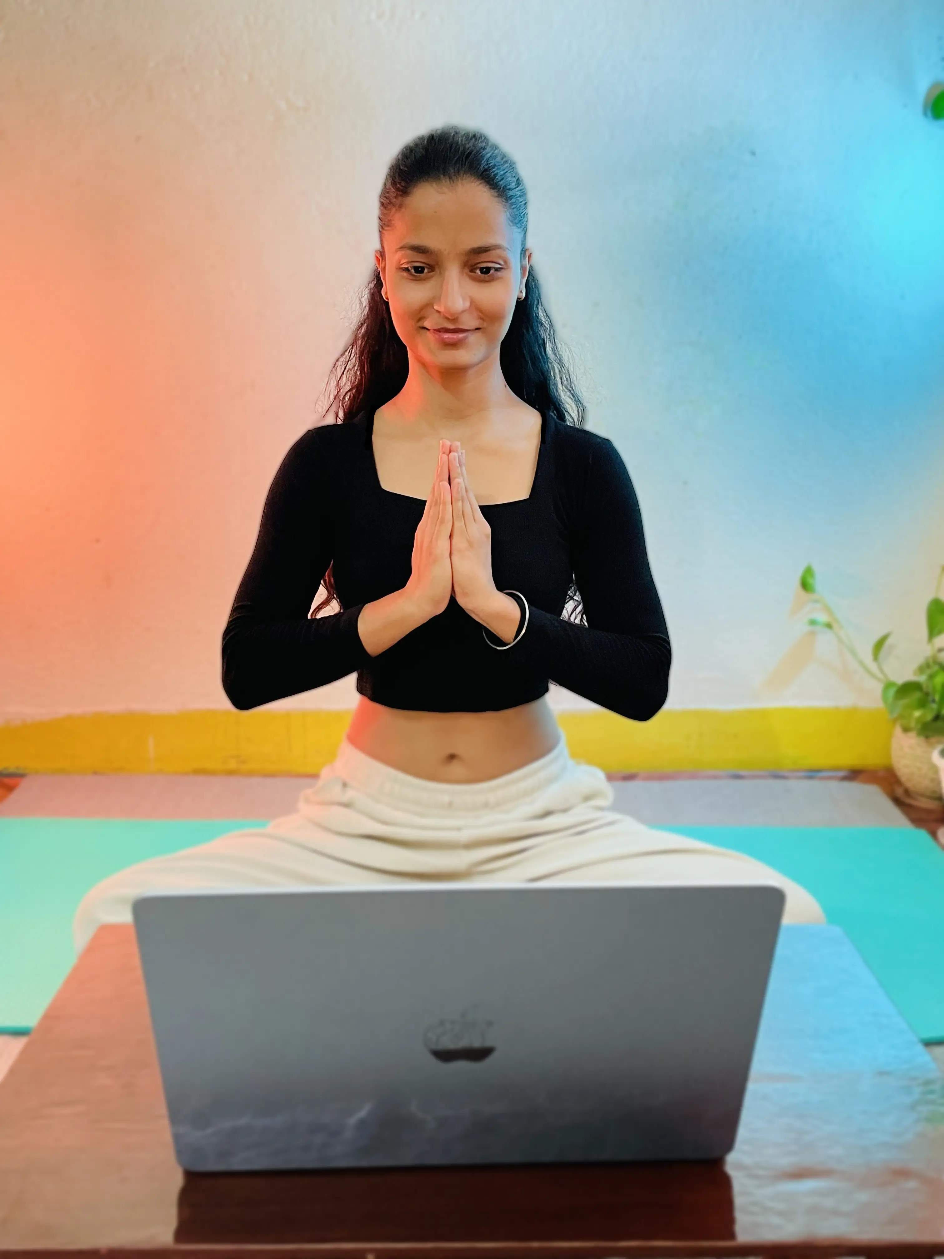 Sneha teaching online yoga in a calm studio setting
